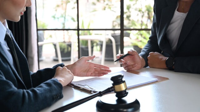 Female lawyer explaining terms, condition on legal document to client before signing on contract at law firm
