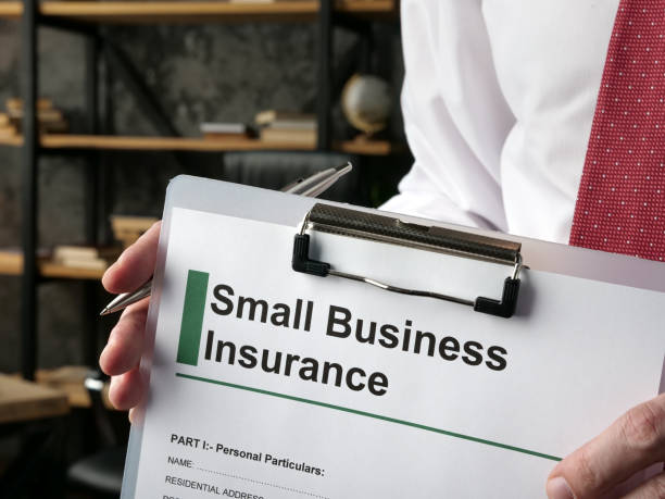 A Hand holds clipboard with application small business insurance.