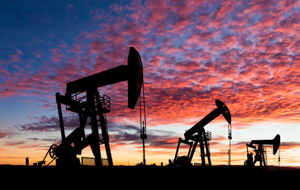 Working oil pumps against a sunset sky.
